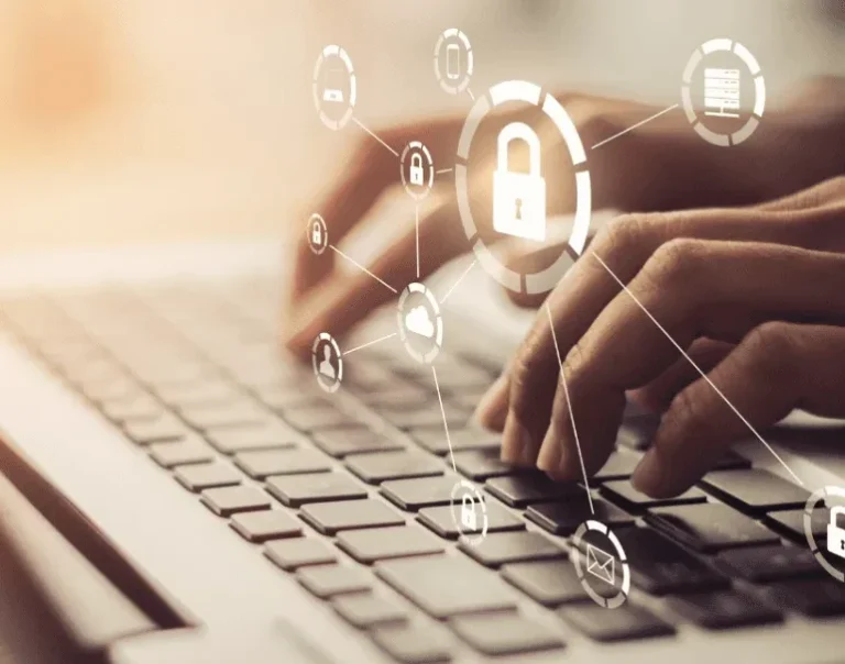 Hands typing on a laptop keyboard with digital security icons overlayed.