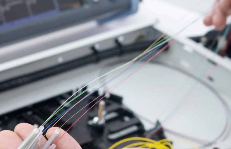 fusion splicing services: A hand holding multiple colored fiber optic cables.