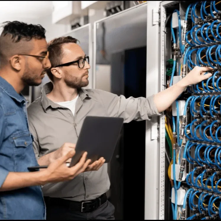 Two technician working Two technicians examine server equipment and network cables in a data center.
