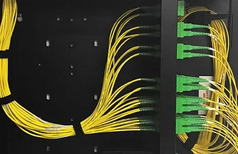 Yellow and green fiber optic cables organized in a network equipment rack commercial fiber solutions Buffalo NY